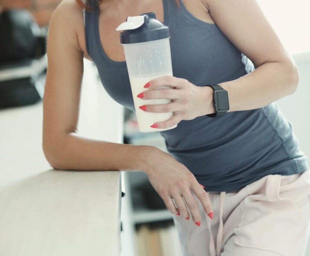 Mulher segurando a garrafa de whey protein